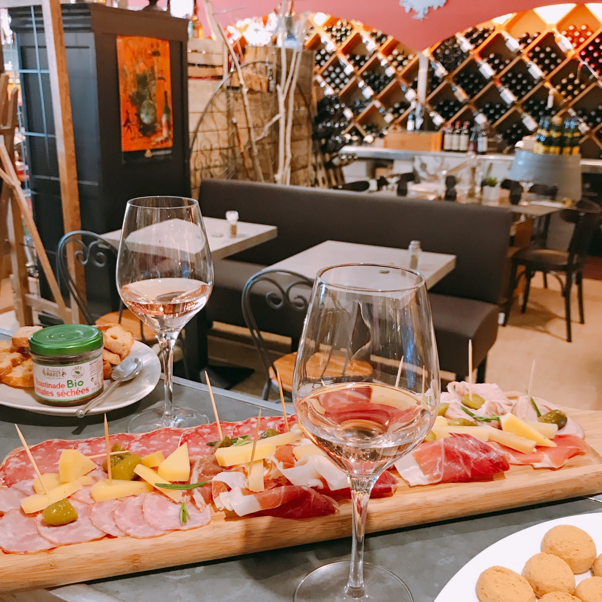 Une planche de charcuterie et fromages composée sur une longue table du bistrot