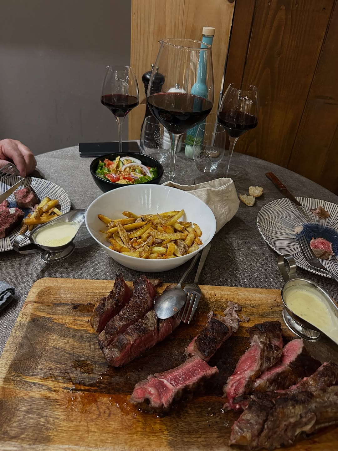 Une table généreuse à partager : côte de bœuf, frites maison et verres de rouge